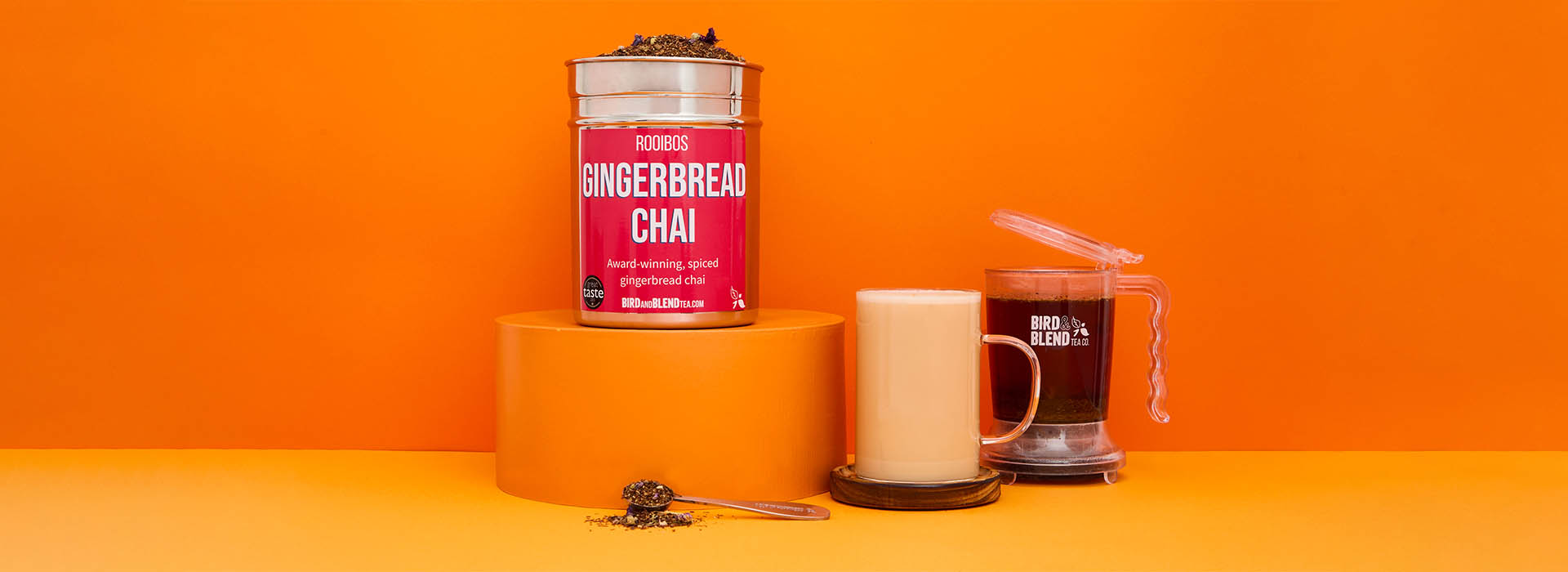 A tin of Gingerbread Chai tea with a gingerbread chai latte